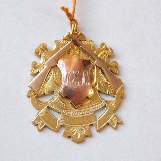 Circa 1913 9ct gold fob pendant with rifle decoration